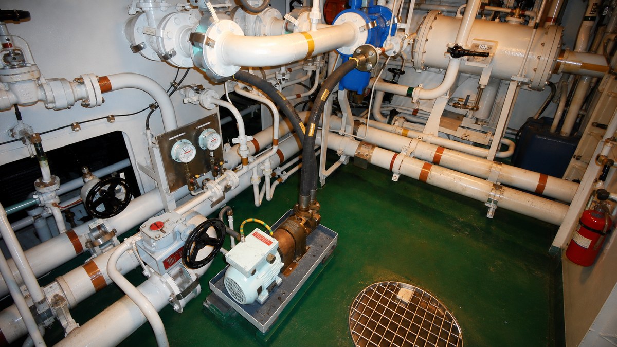 Mangueras curvas de caucho a medida para el sector naval e industrial 2 Manguera de caucho conectada a una bomba en una sala de máquinas naval