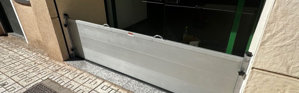 ¿Cuánto cuesta una barrera anti inundación? Inversión frente al coste de una inundación 1 Precio de una barrera anti inundación: barrera de aluminio montada en el acceso de un local comercial